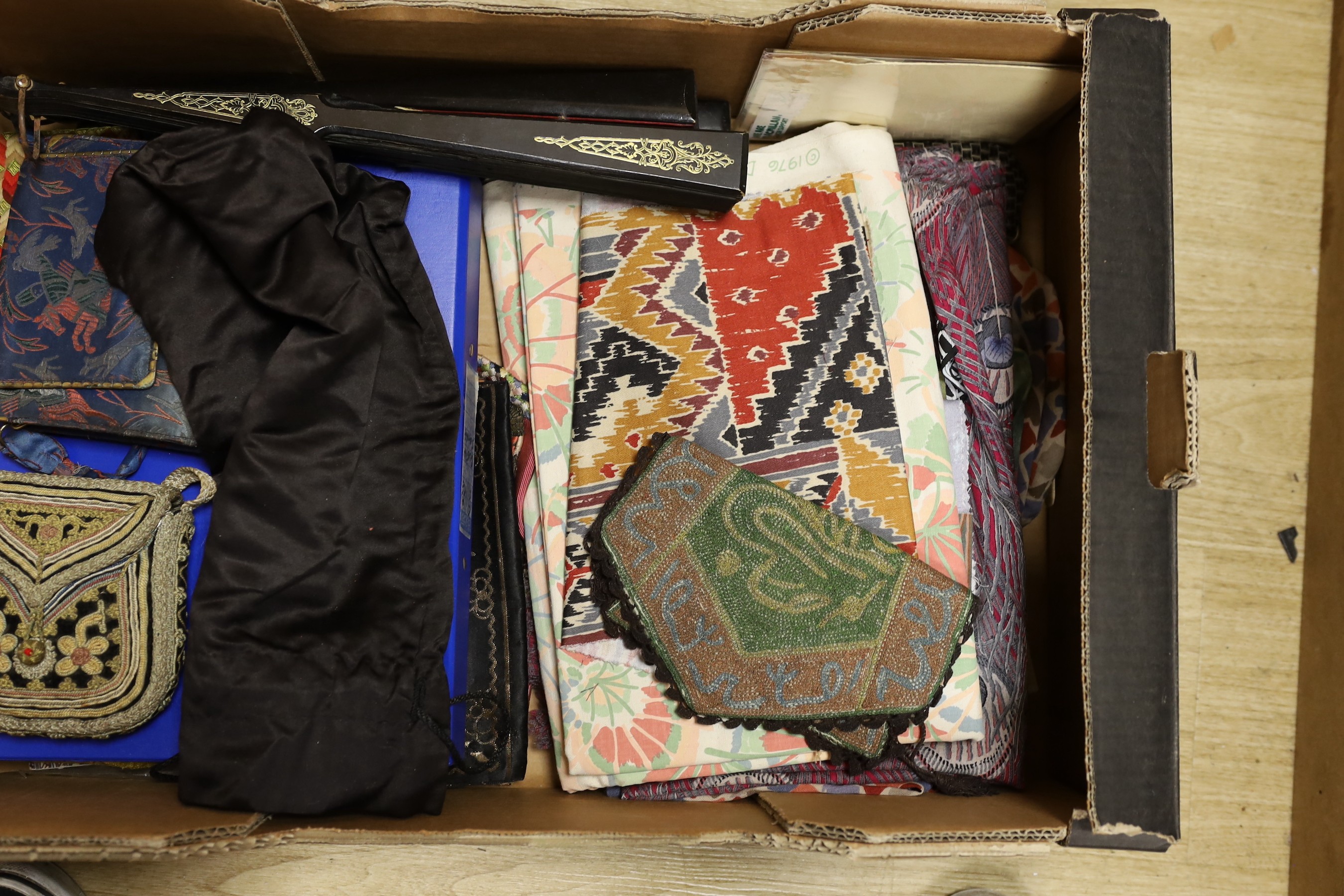 A collection of various fabric samples, fabric bags and a pink parasole